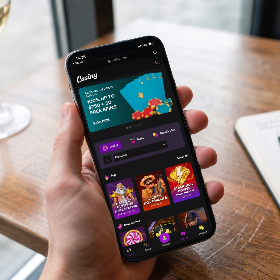 An iPhone 13 in hand running the Casiny mobile casino in Safari over 4G, a pokie spinning in the browser; the status bar shows network and time.